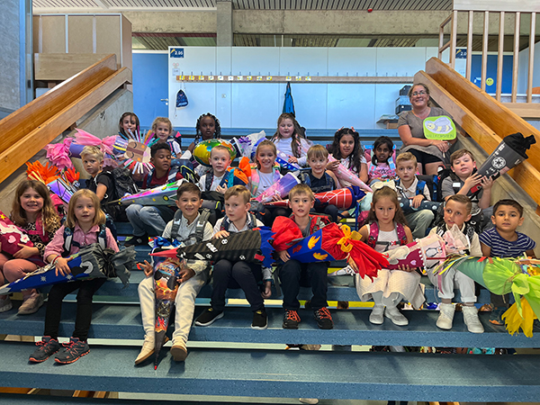 Schulkinder mit Schultüte sitzend auf einer Treppe zur Einschulung 2025/2026